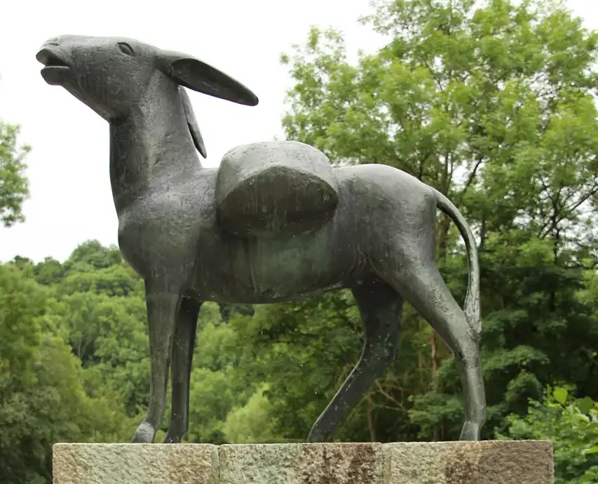 Bronzeskulptur eines Esels mit Lastsack auf dem Rücken, den Kopf erhoben, an der Eselsbrücke über die Tauber