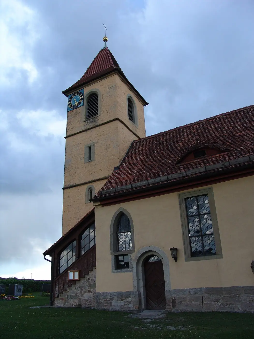 Kirchturm von St. Maria und Michael in Kirnberg vor einem wolkigen Himmel